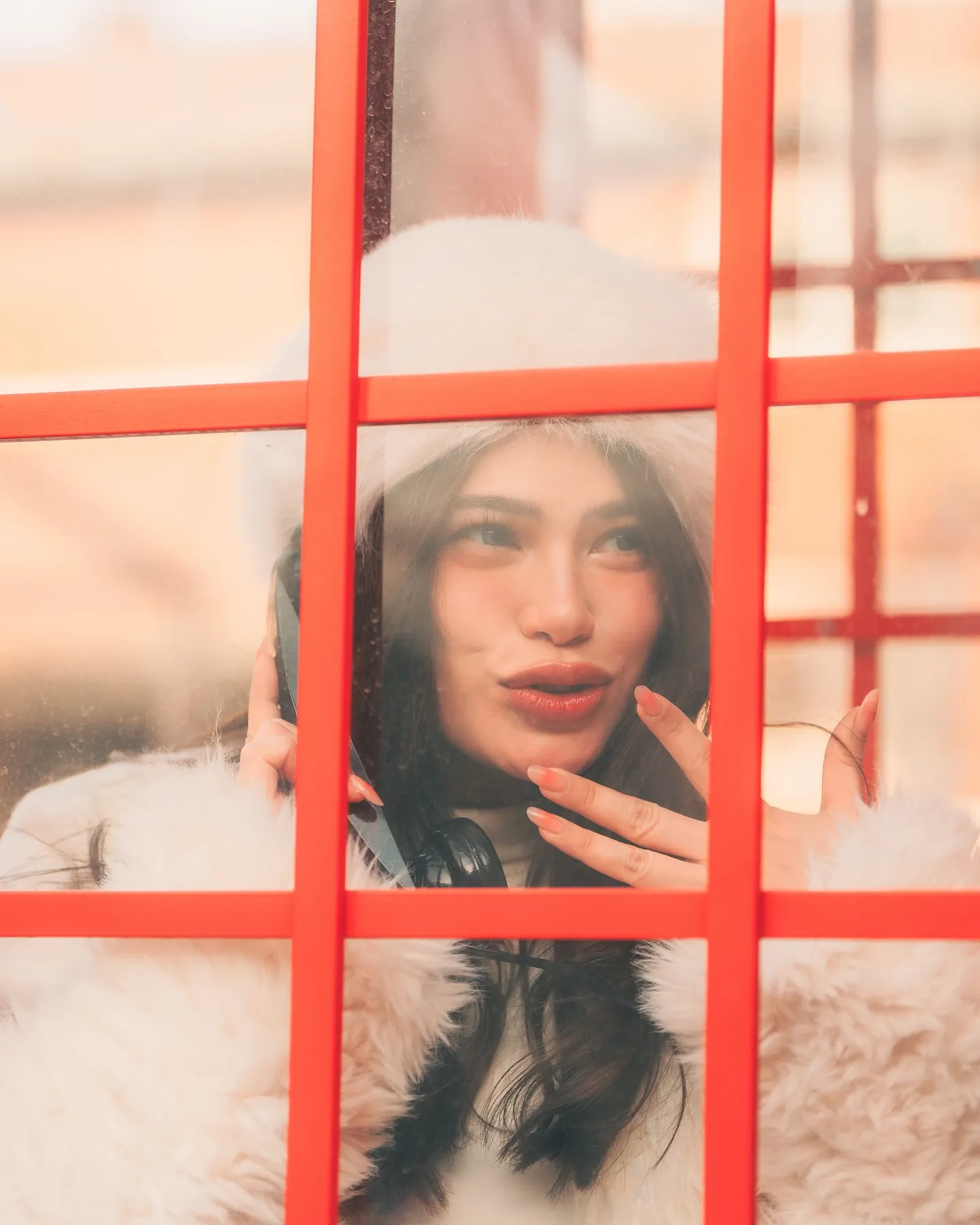 Denise Laurel pressed to the booth glass, mid-laugh