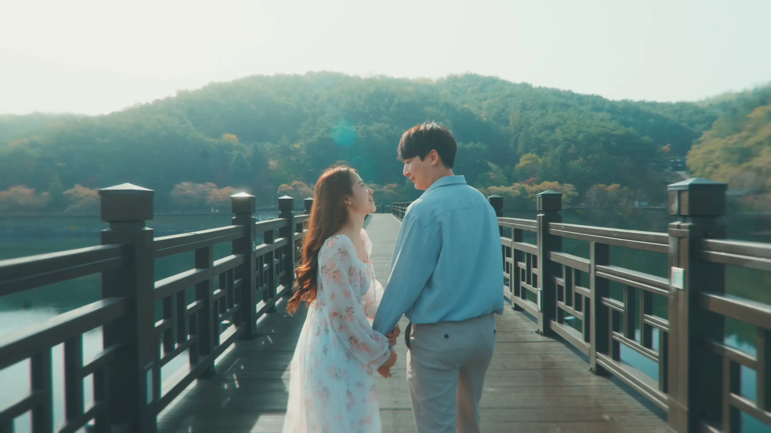 Kristel and Suhyuk at the Andong riverside in golden light, the bridge behind them.