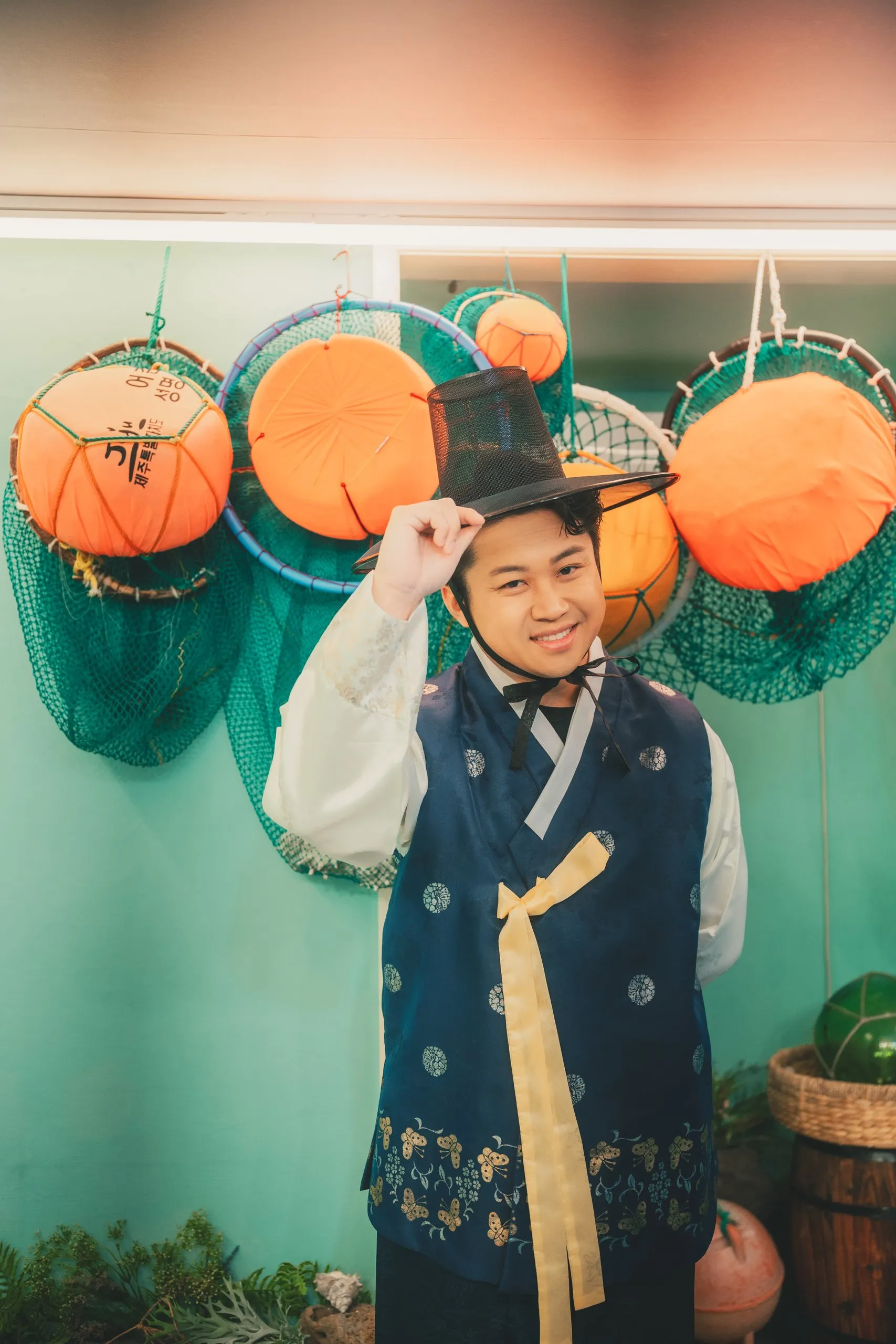 Ivan in hanbok under the orange lanterns of the studio
