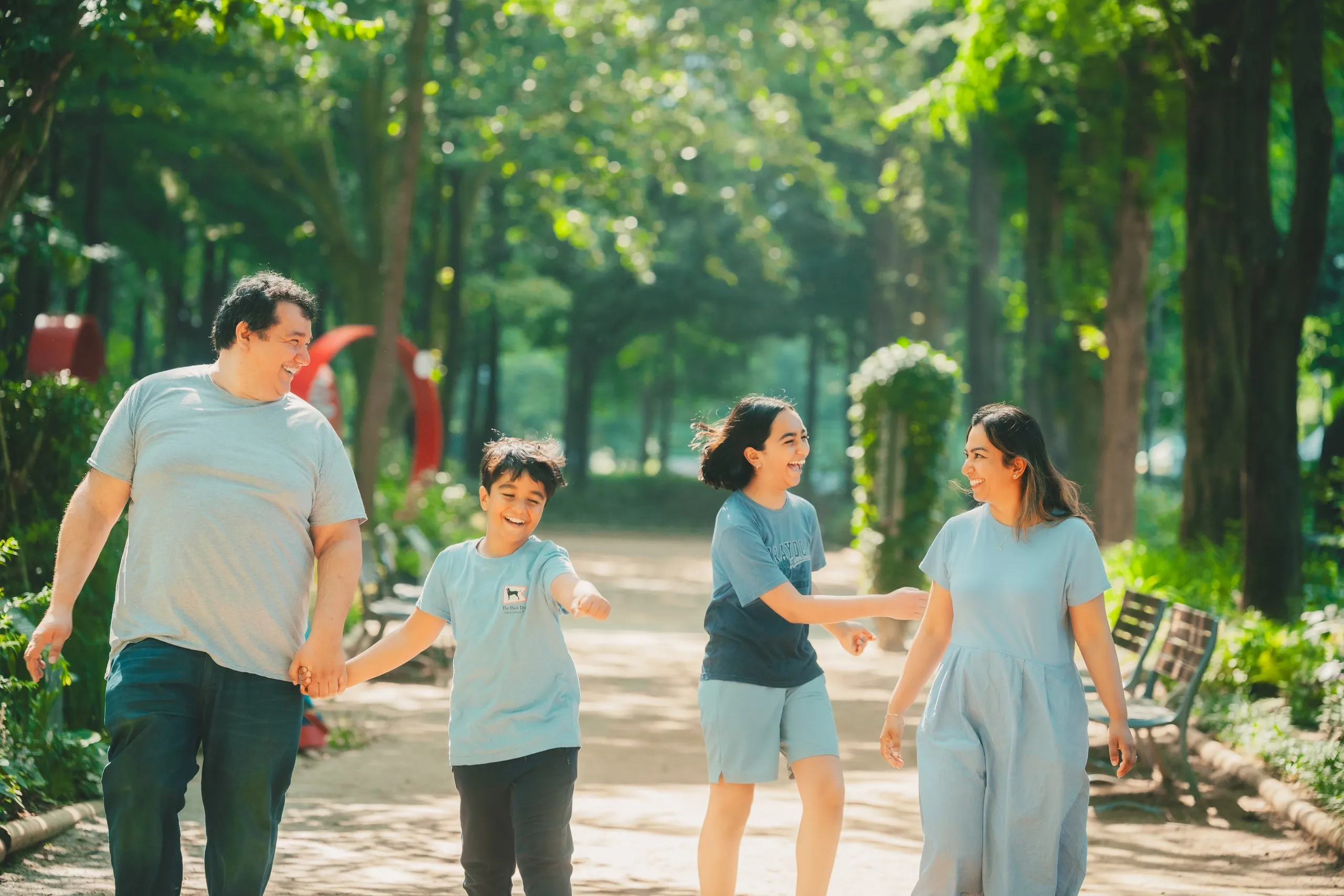 The Khidhir family walking hand in hand through Seoul Forest