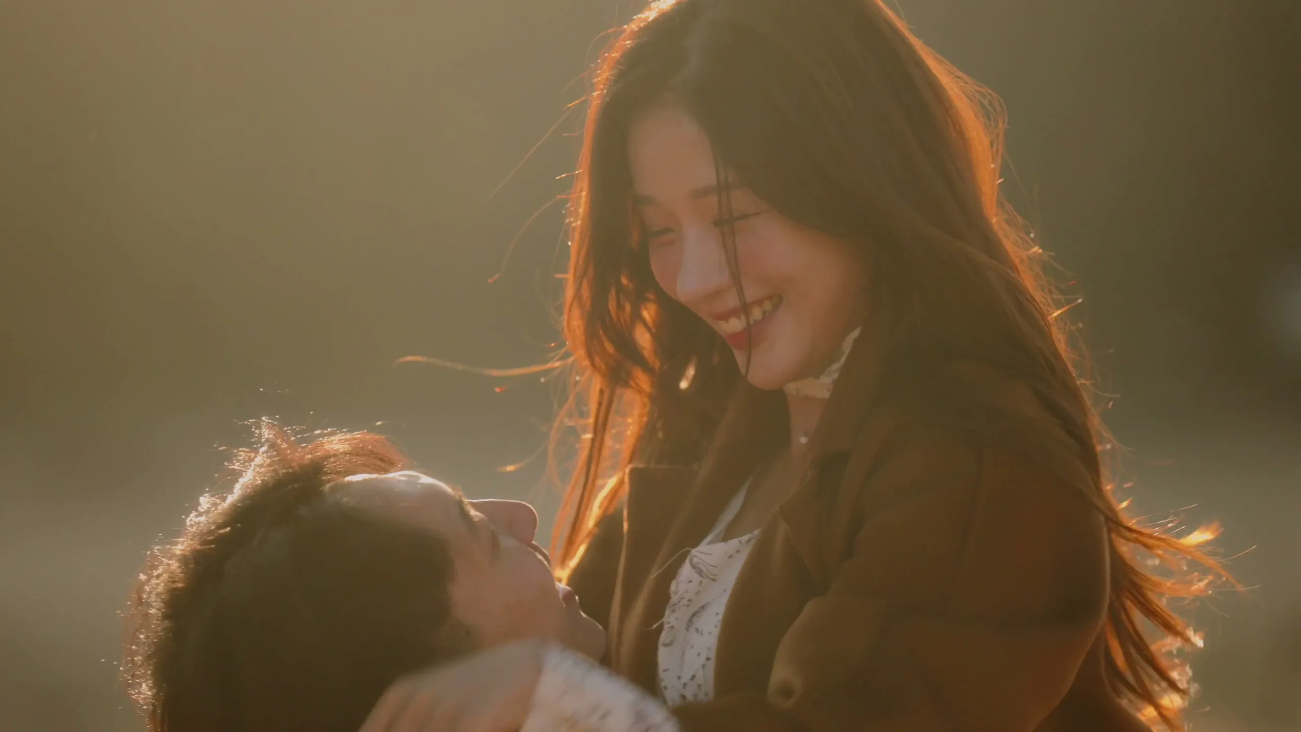 Golden hour in the field, her hands on his face