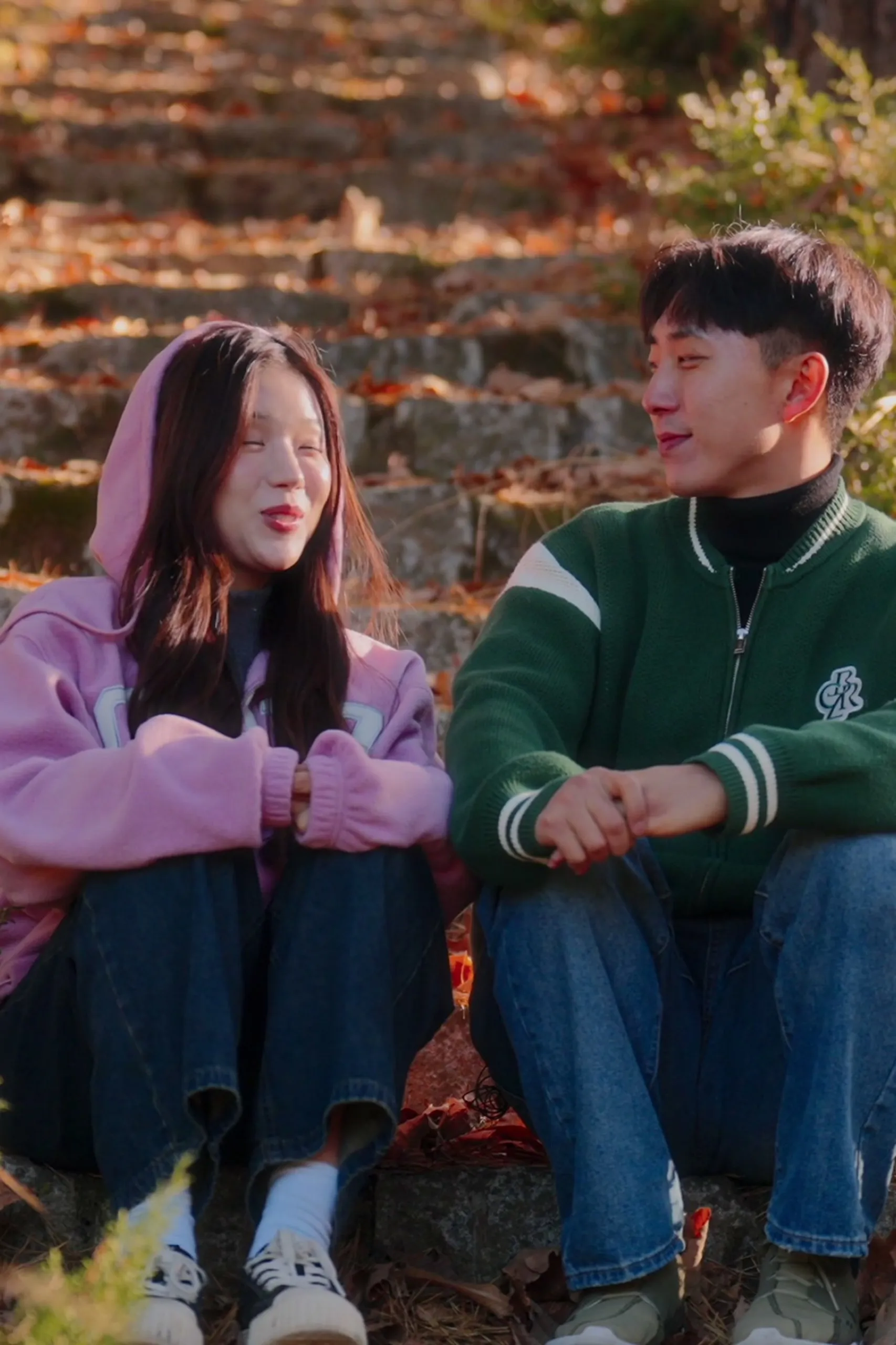On the steps in the autumn woods, the two of them seated shoulder to shoulder.