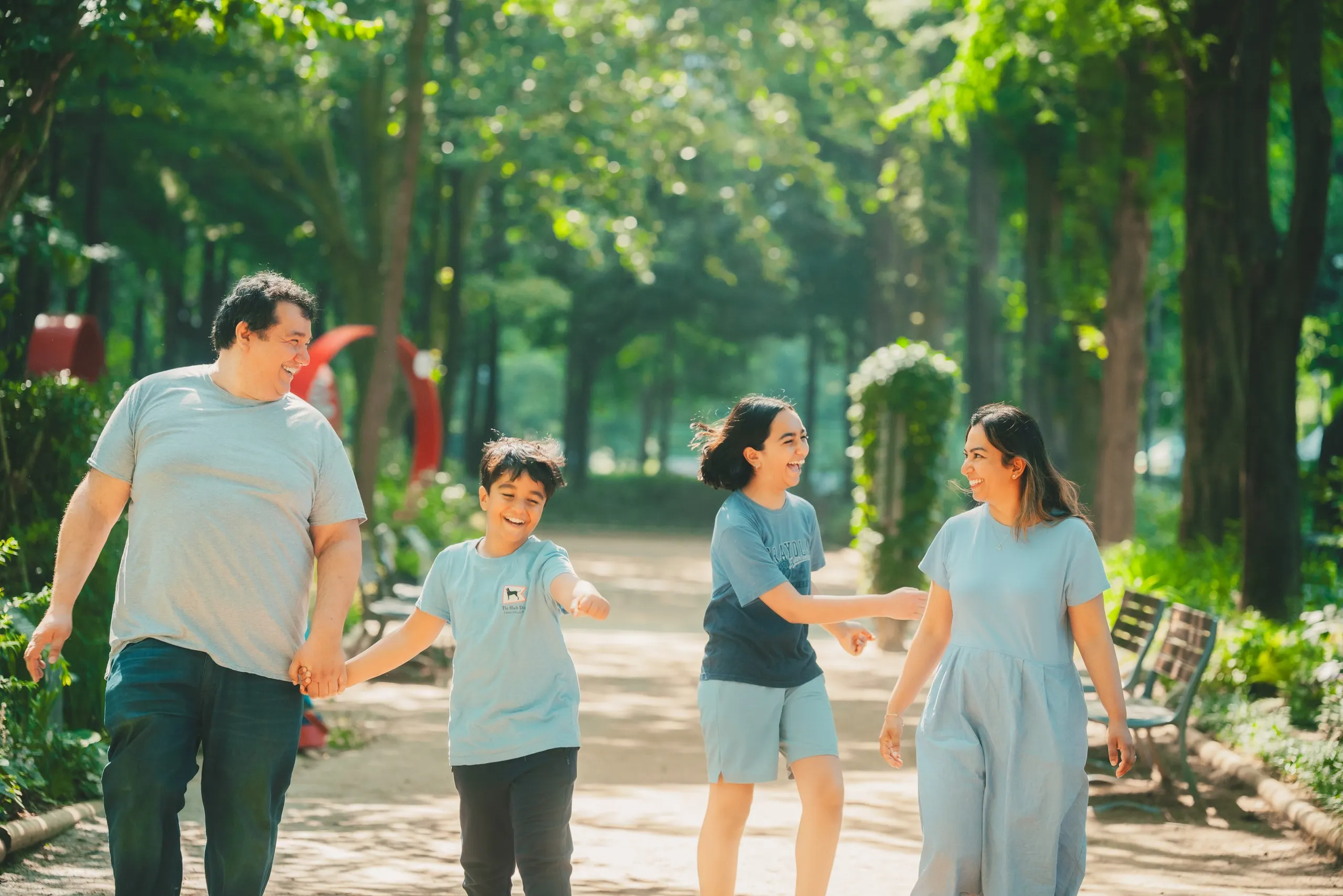 The Khidhir family walking hand in hand through Seoul Forest