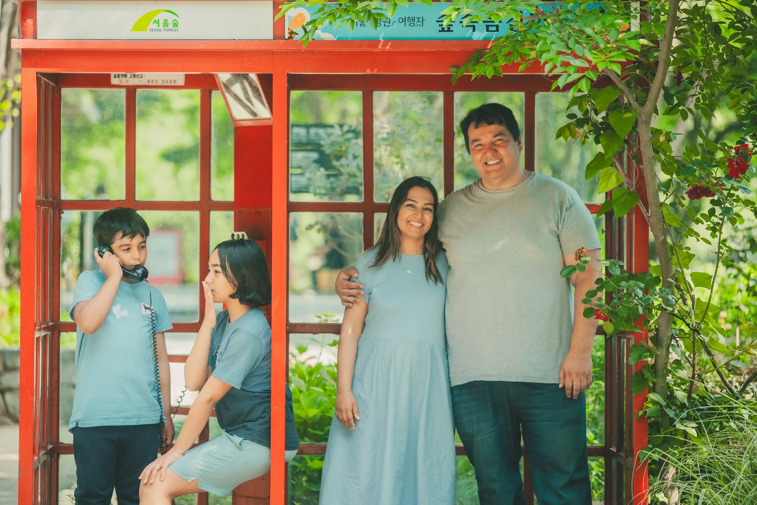 The family together at a red phone booth in Seoul Forest