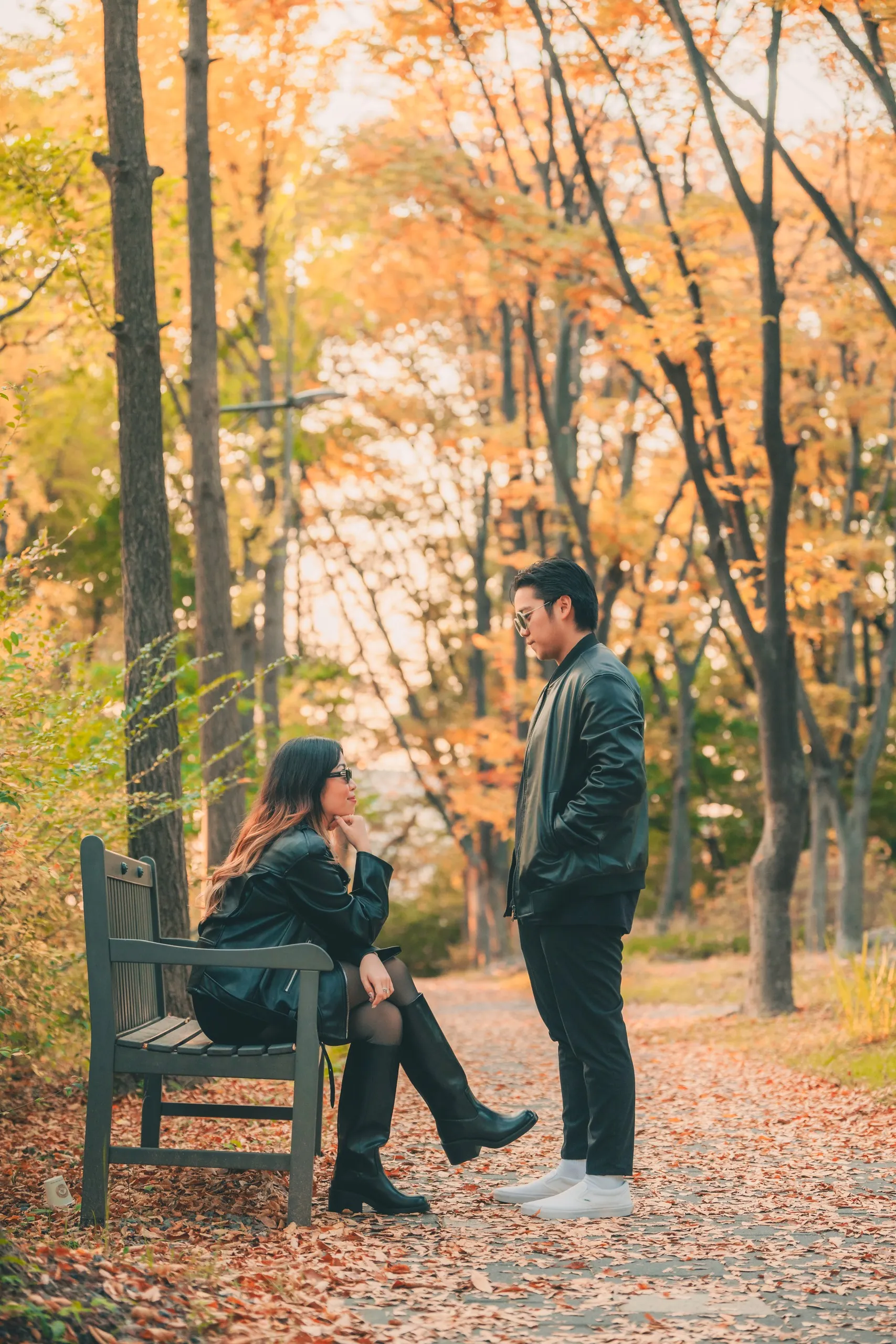 A couple on a park bench among fallen leaves