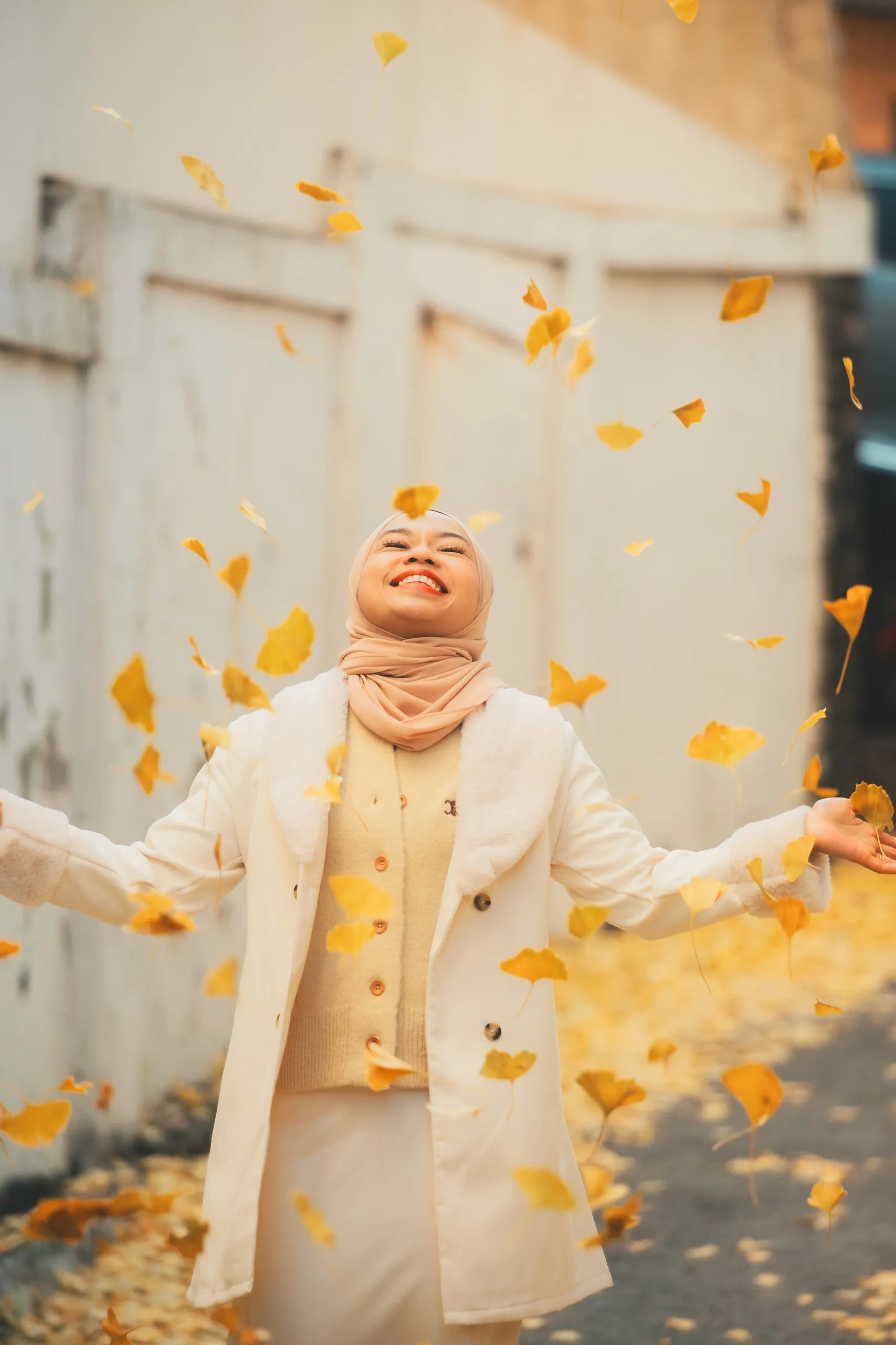 Adila laughing as ginkgo leaves fall around her