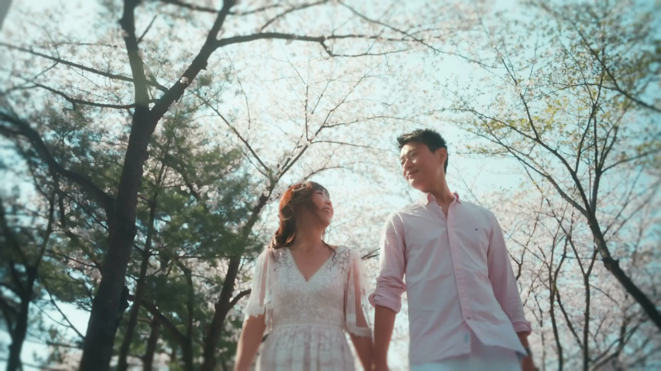 Christy and her partner in a cherry-blossom tunnel