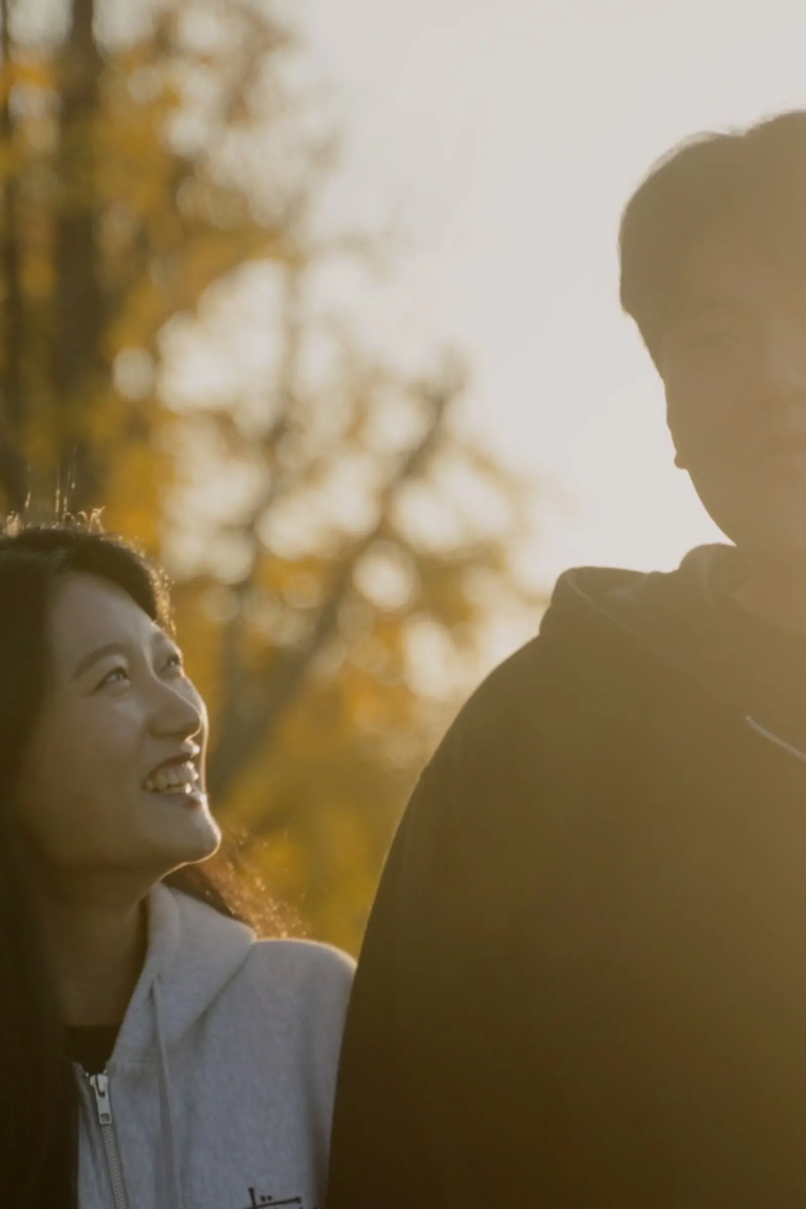 Haeseong and Chaeyeon close together in warm backlight at golden hour.