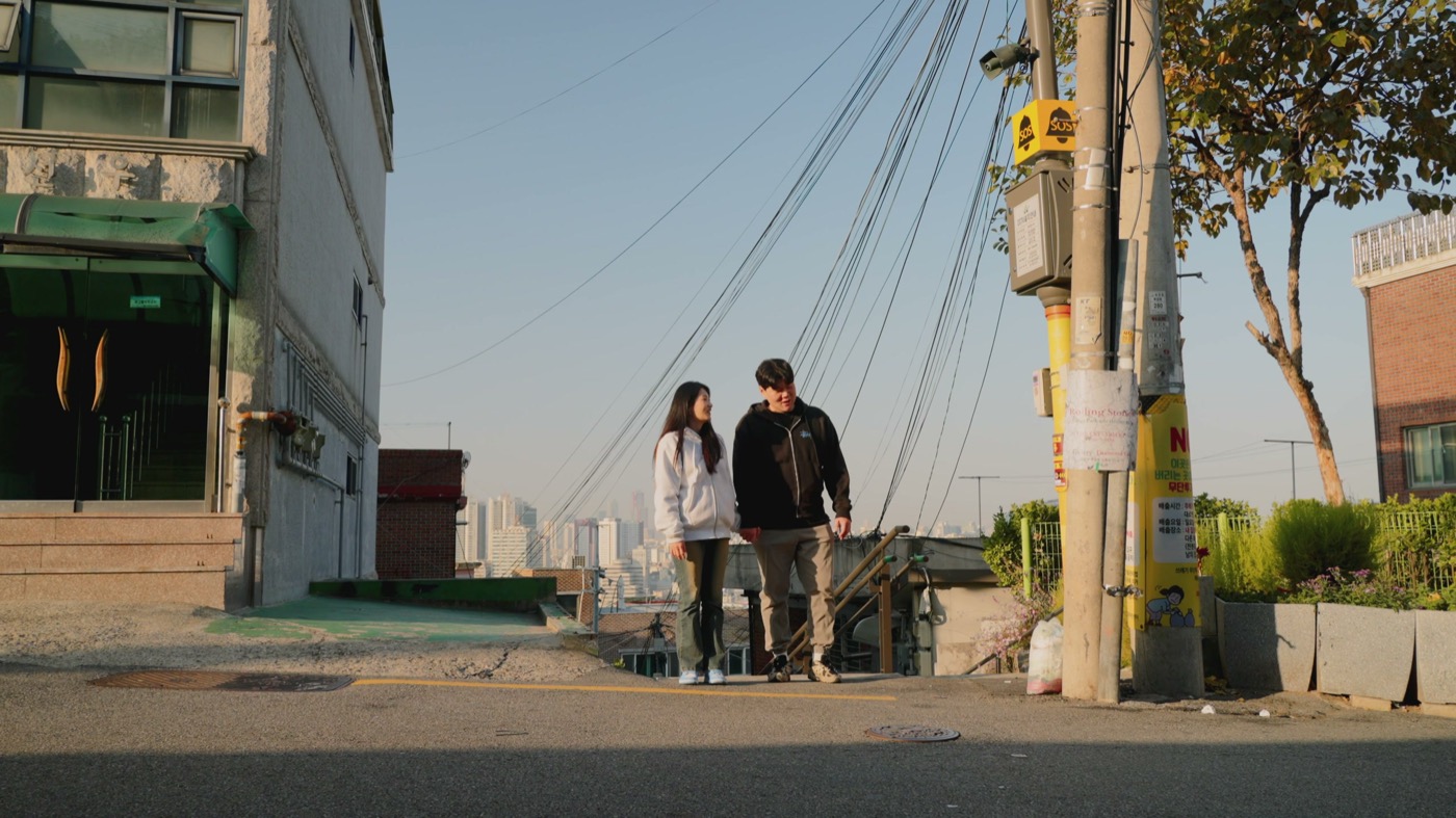 A couple on a hillside street in Haebangchon.